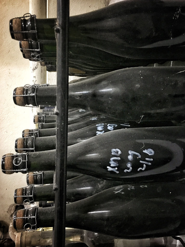 aging wine bottles on top of each other in 'Domaine Karanika' cellar